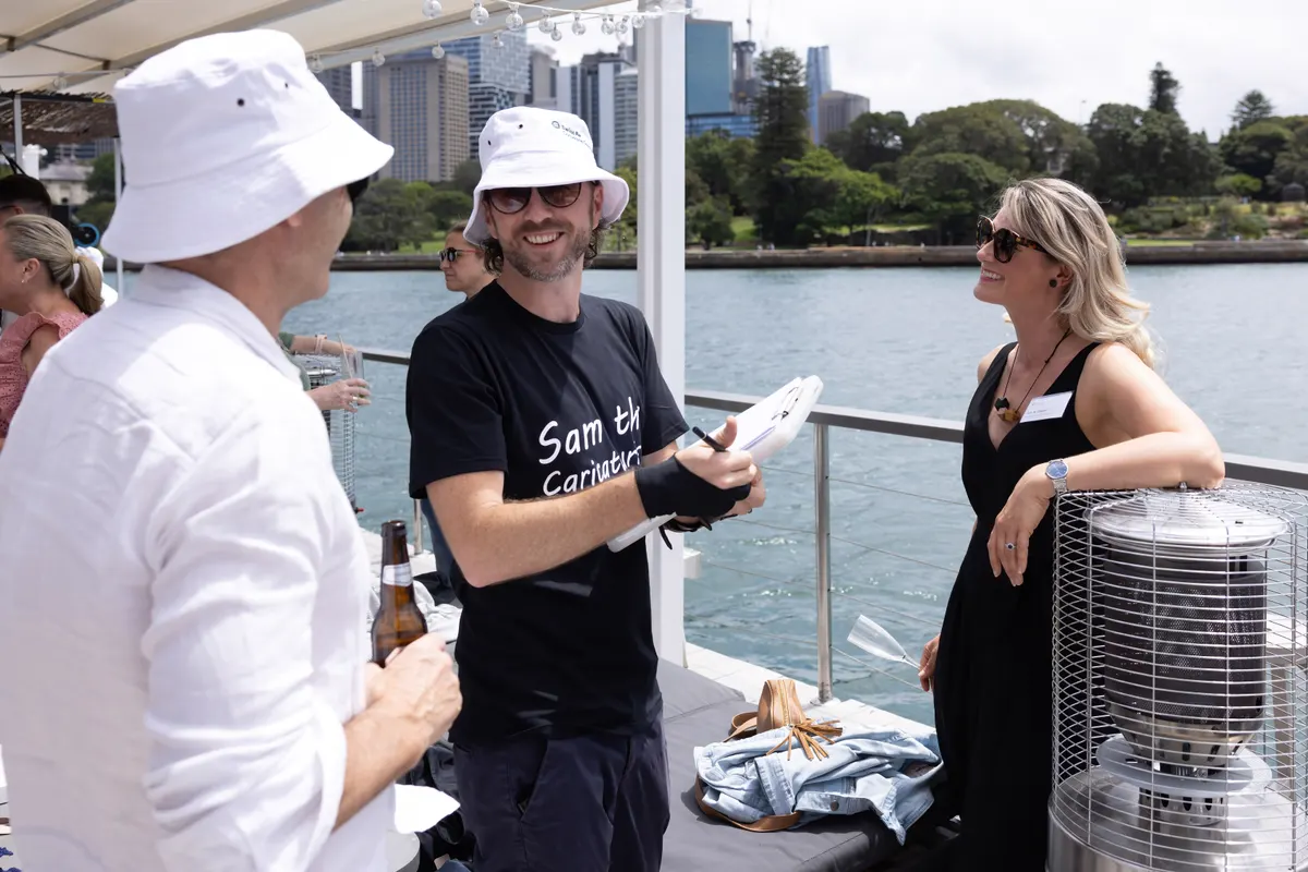 Sam drawing a caricature on a harbour cruise